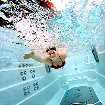 Underwater view of a woman smiling and swimming.