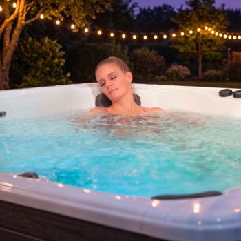 Woman relaxing in a swim spa with massaging jets.