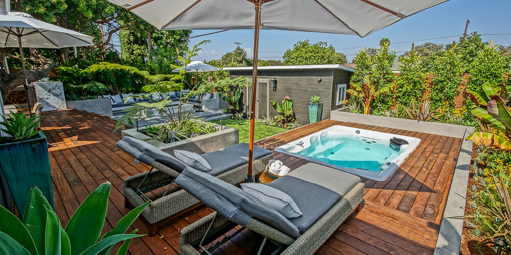 A swim spa installation on top of a backyard deck.