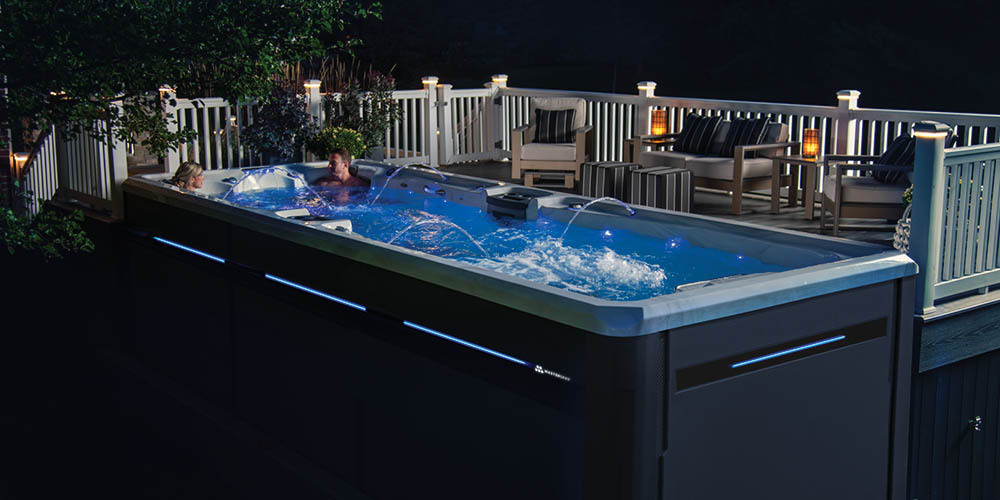 H2X Challenger swim spa at night next to a deck.