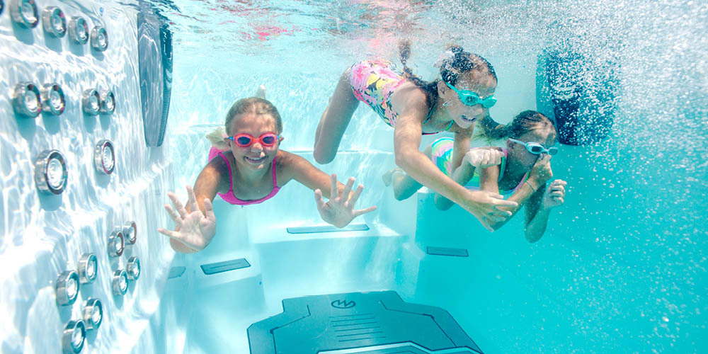 Underwater shot of kids enjoying a swim spa.