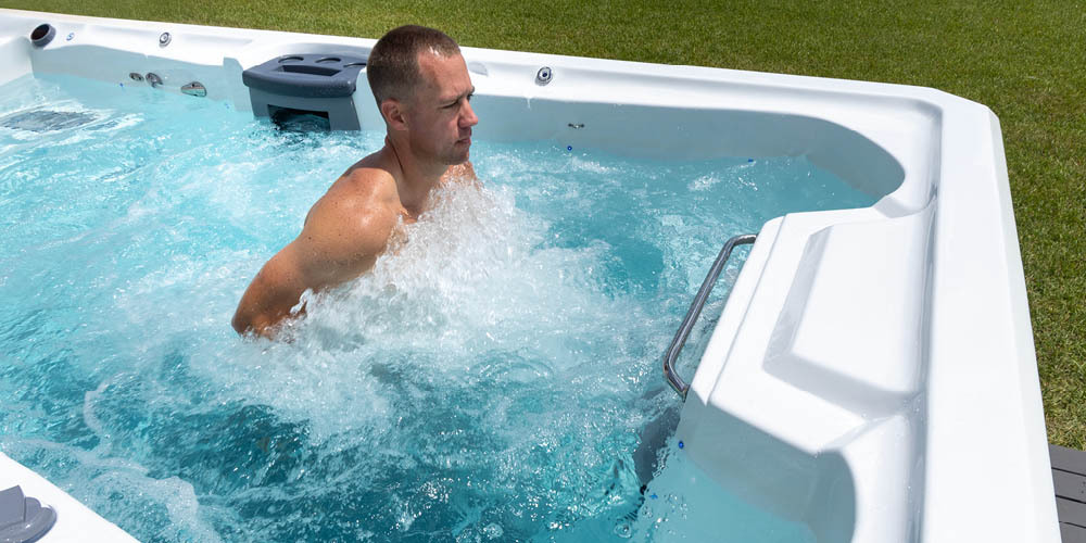 Man jogging against the water current for exercise in a swim spa.